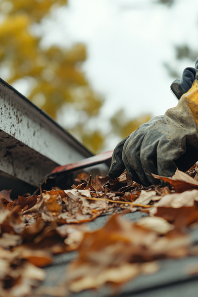 Roofing worker cleaning roof debris after a storm. Featuring sto